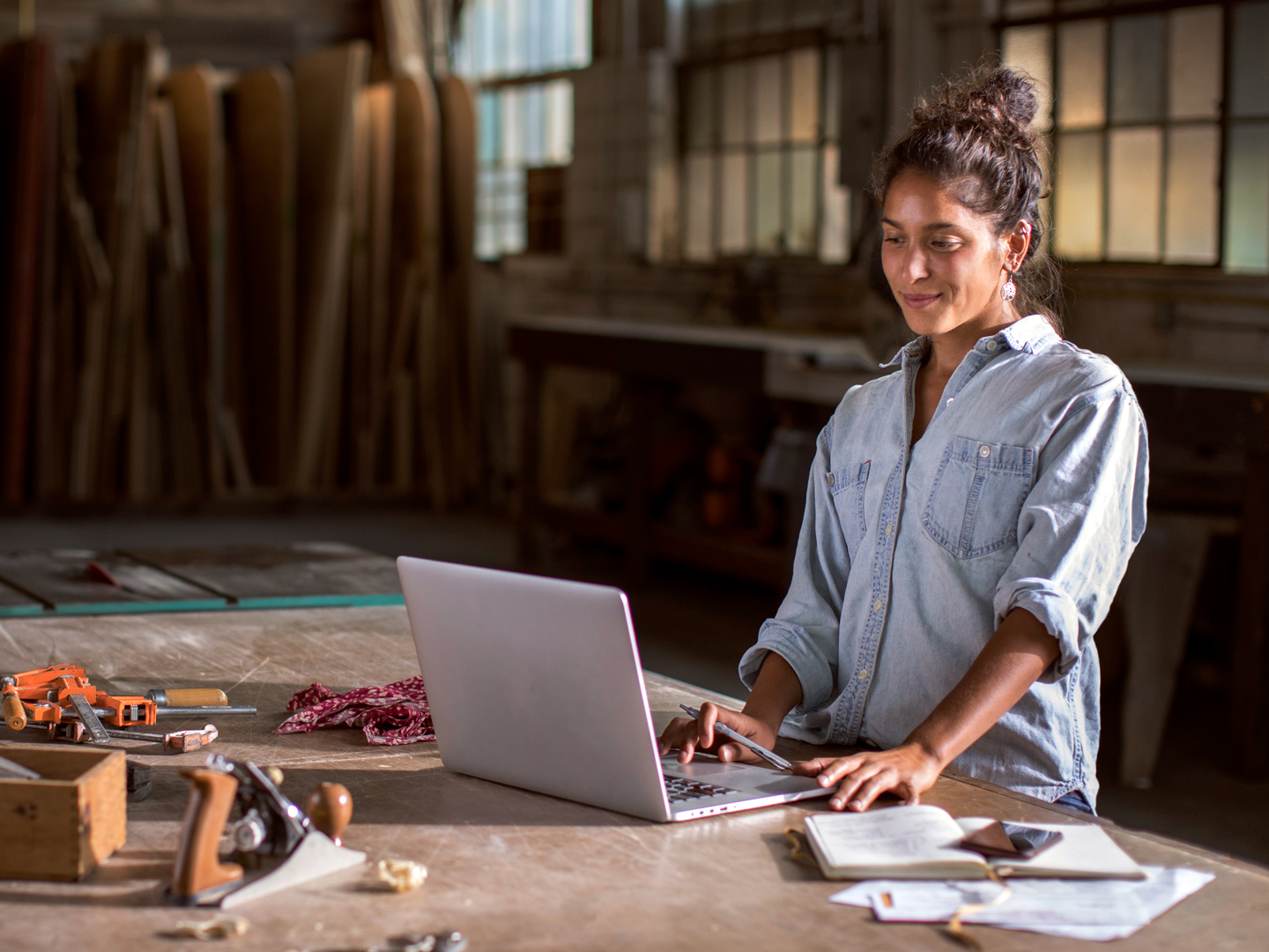 woman using a laptop in a woodshop