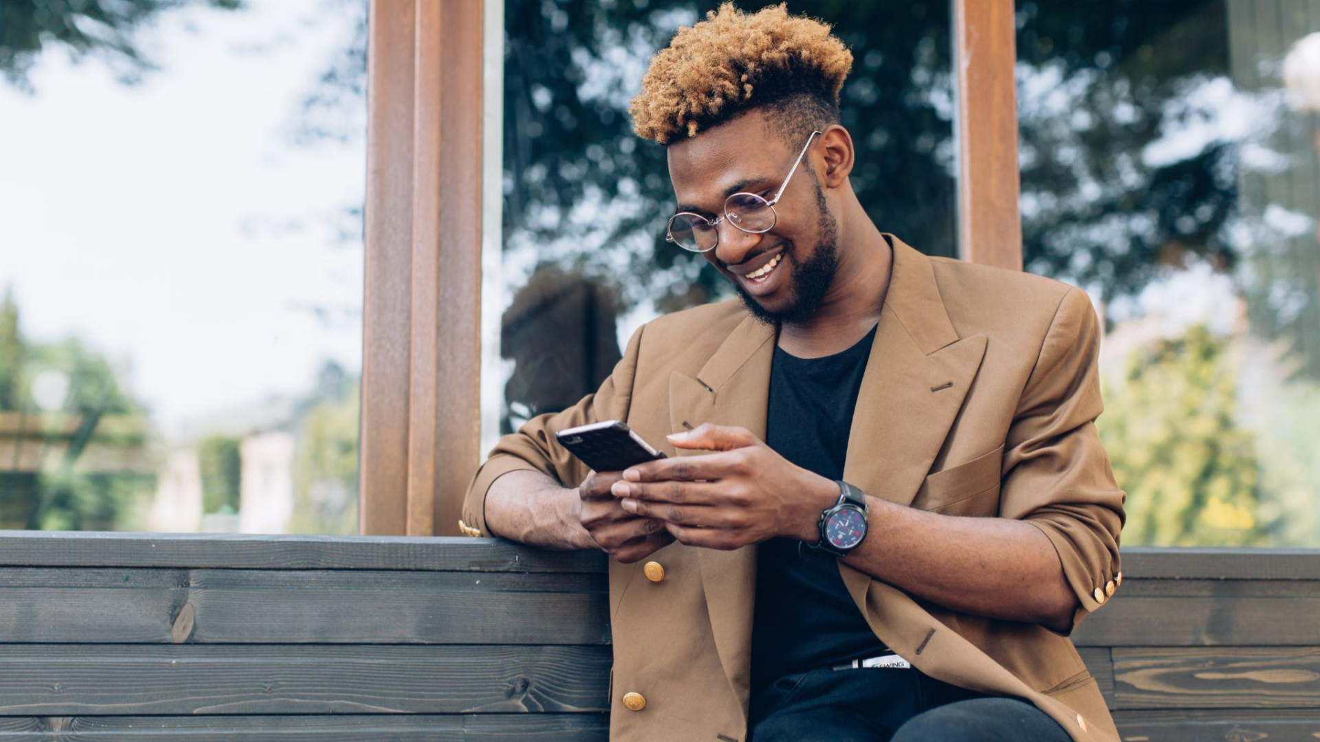 Person sitting on a bench looking at their phone