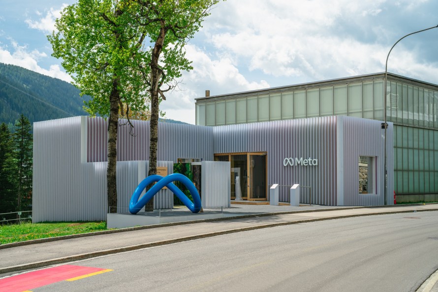 Building with a Meta logo on it. Mountain in the background.