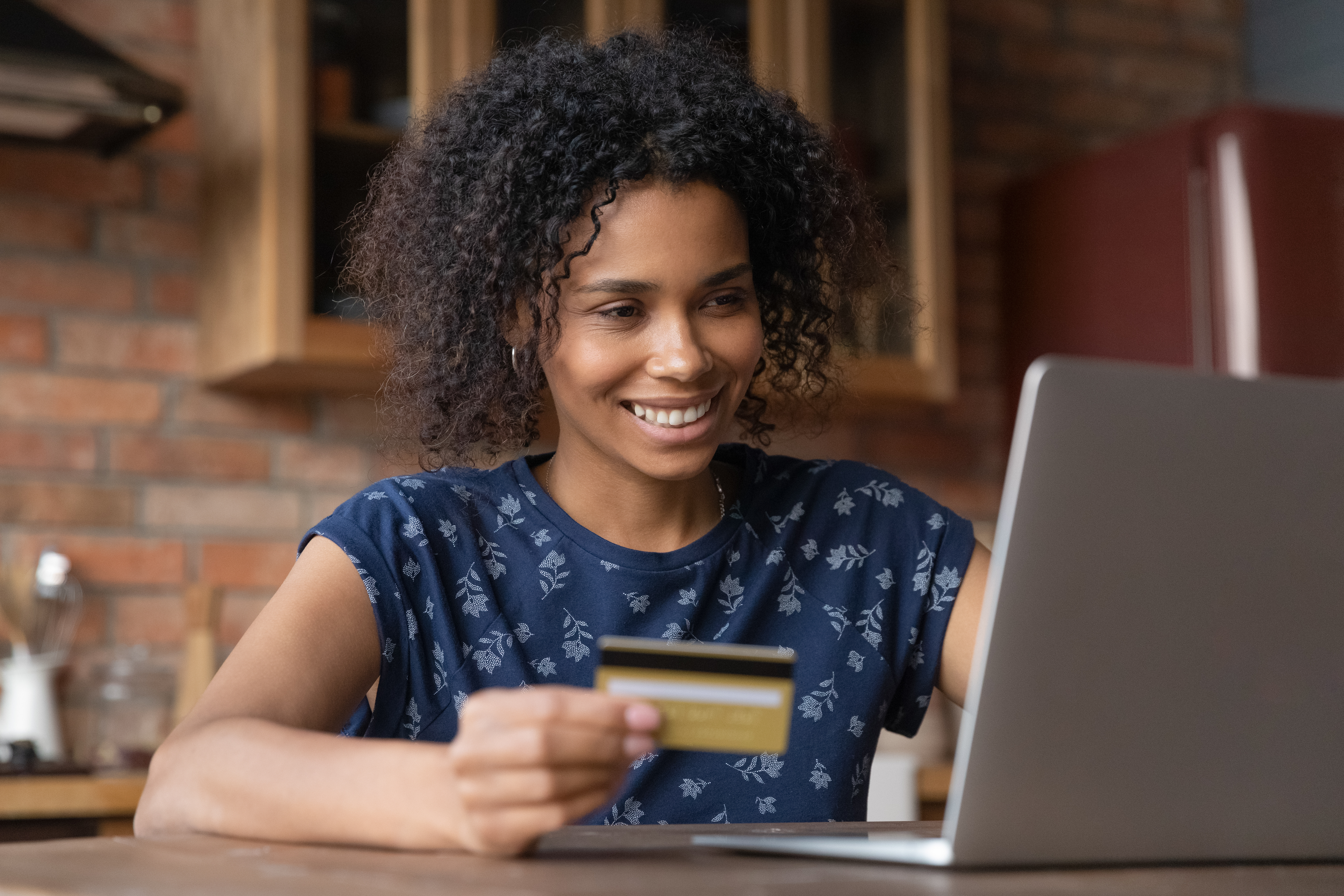 Woman using credit card on laptop