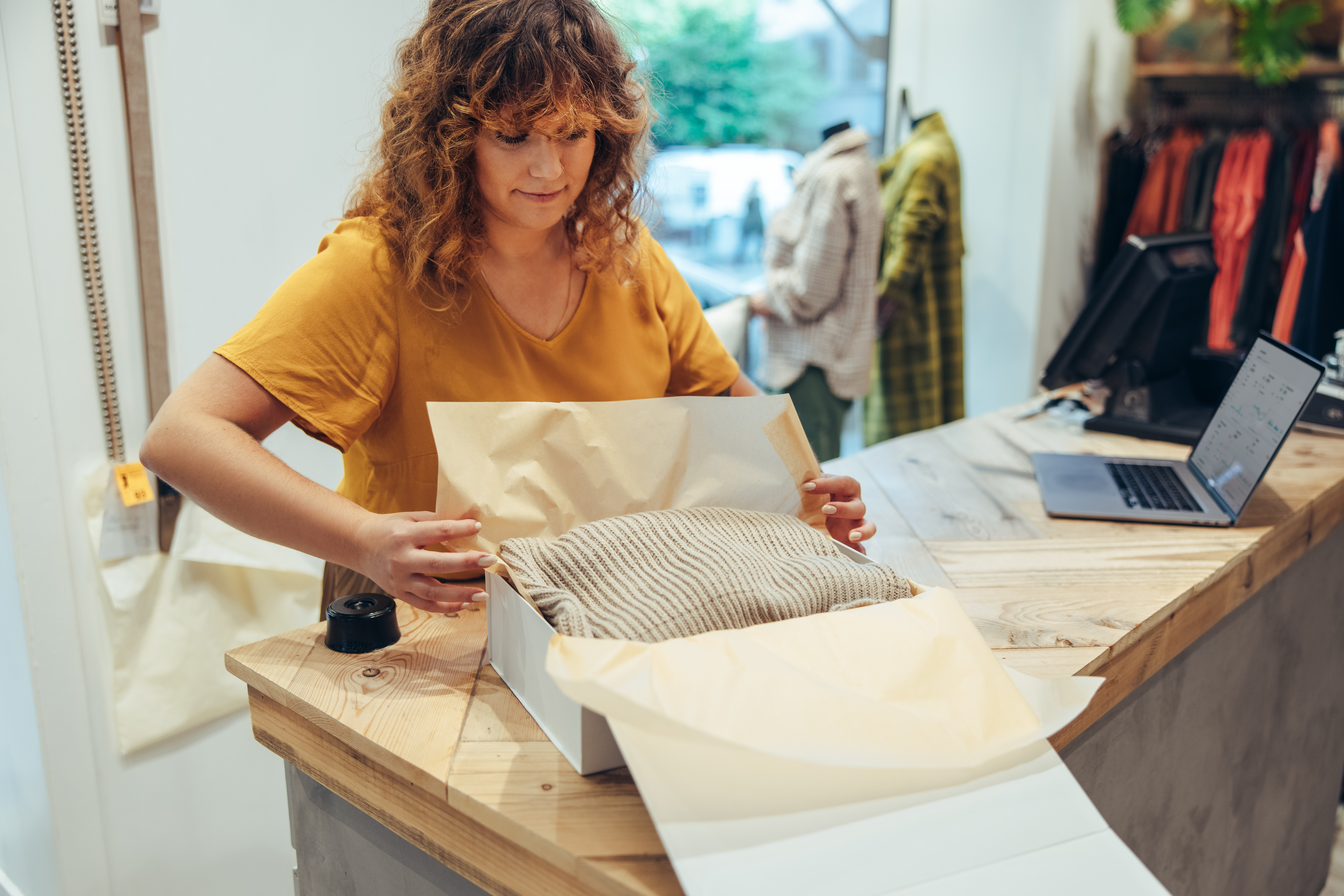businesswoman packing clothes for delivery