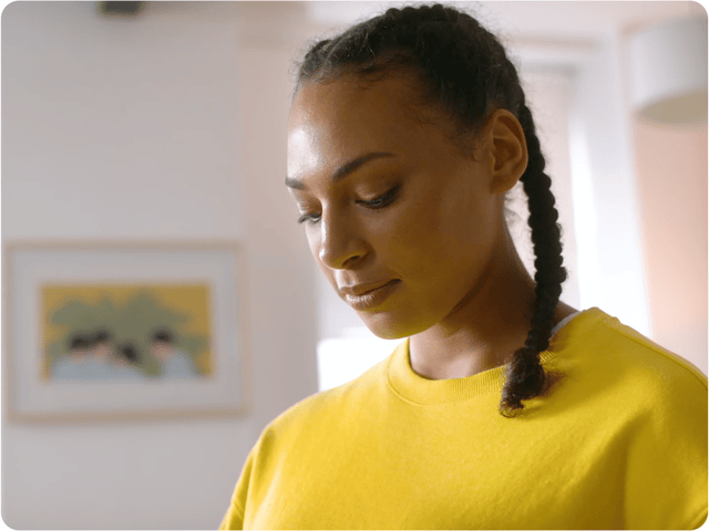 A GIF of a woman putting on a Quest 3 headset to see a variety of relaxing images in the Headspace app. 